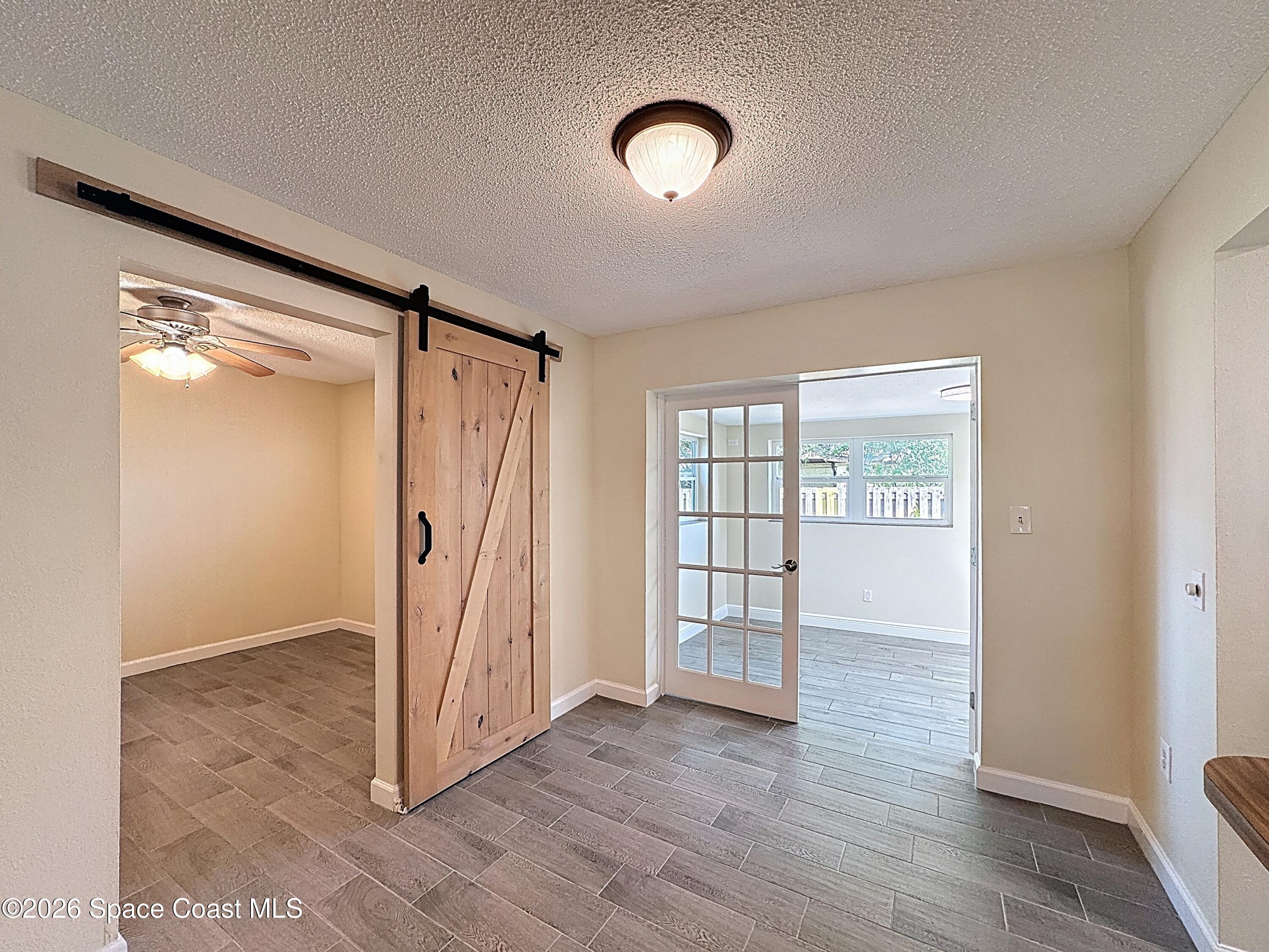 1315 Lester Court Merritt Island, FL 32952 - Photo 13 of 40 an empty room with wooden floor and windows