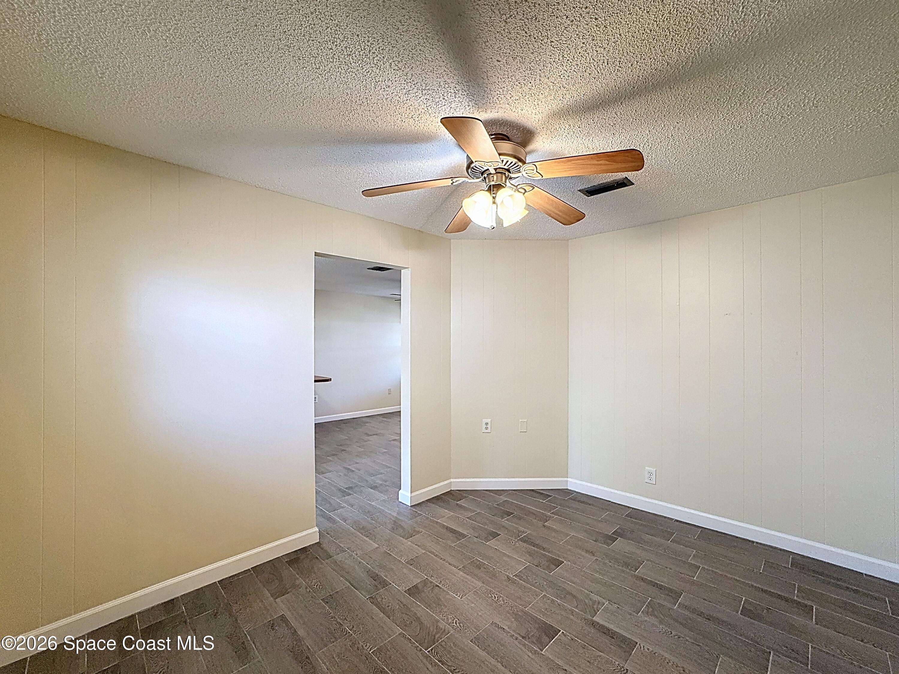 1315 Lester Court Merritt Island, FL 32952 - Photo 15 of 40 an empty room with wooden floor and a ceiling fan