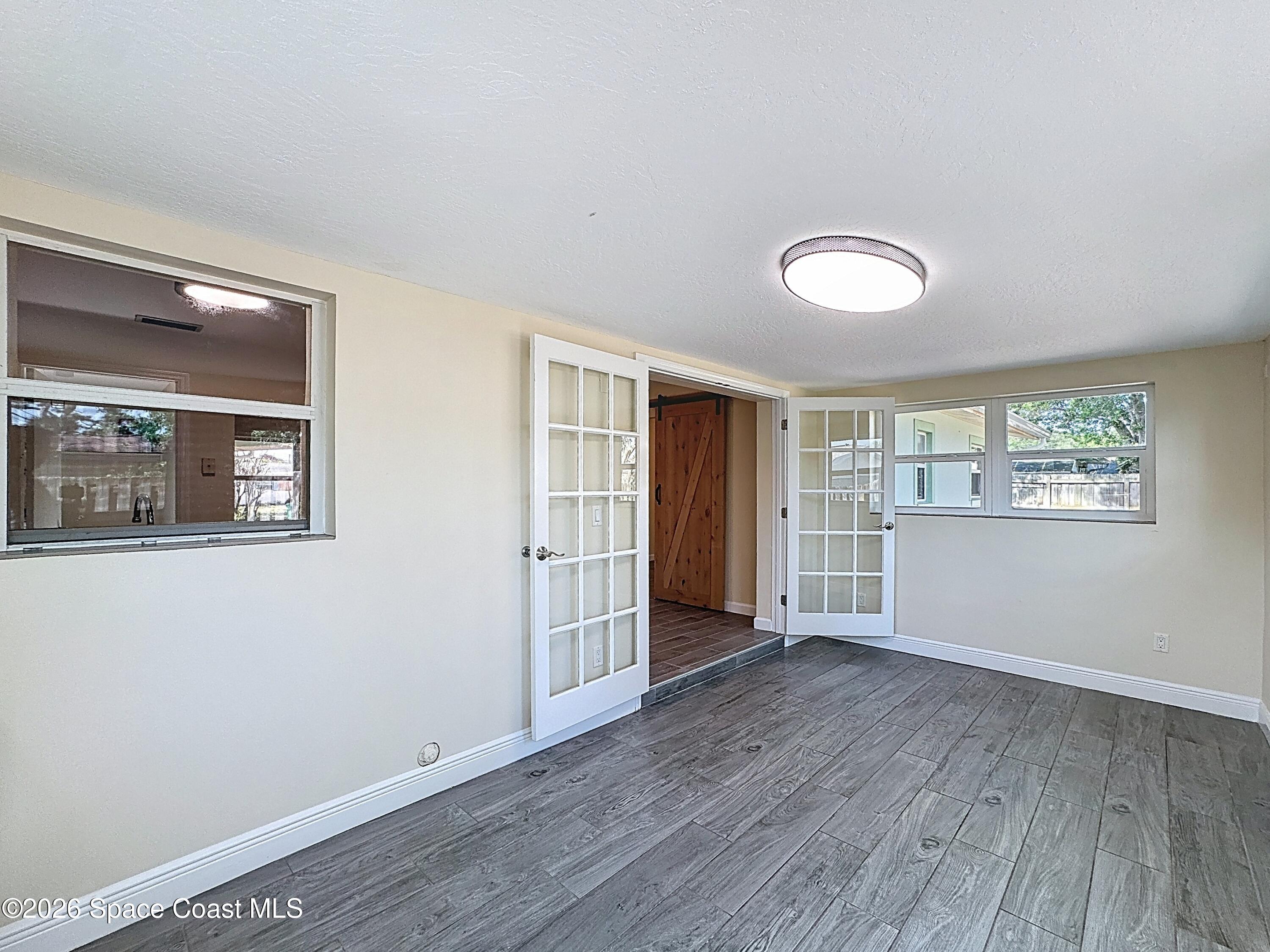 1315 Lester Court Merritt Island, FL 32952 - Photo 16 of 40 an empty room with wooden floor and windows