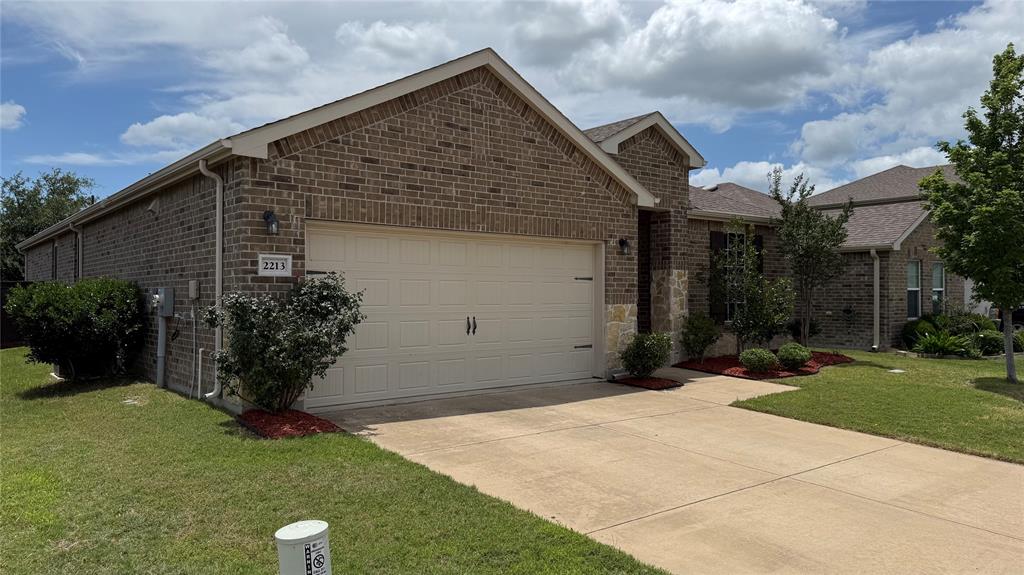 2213 Heaton Street Forney, TX 75126 - Photo 4 of 14 Brick and stone veneer exterior with a two-car garage, concrete driveway, and front landscaping