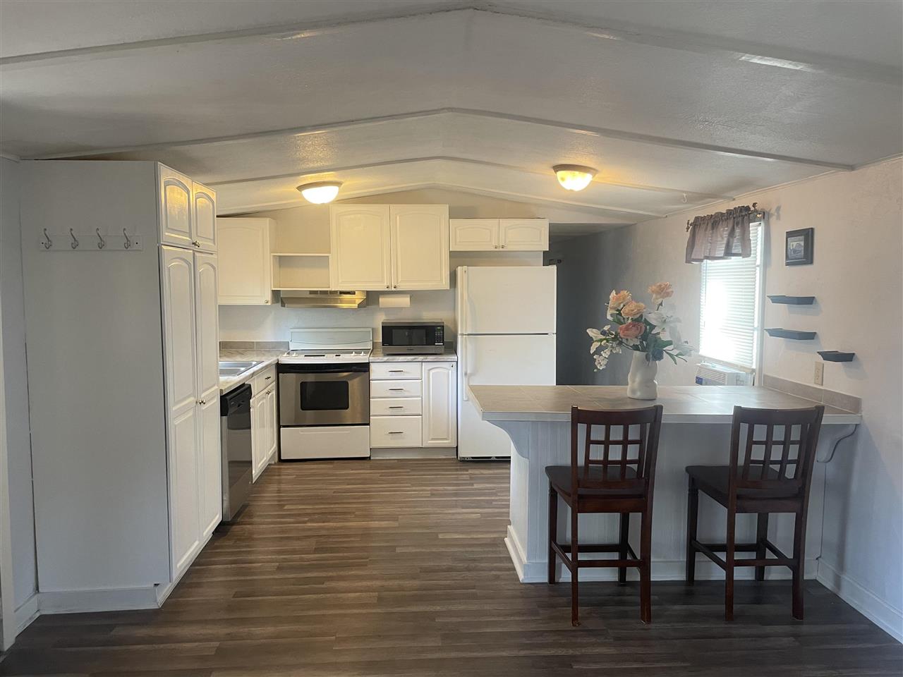 3268 E Road, Unit 43 Clifton, CO 81520 - Photo 4 of 15 a kitchen with stainless steel appliances a dining table chairs and wooden floor