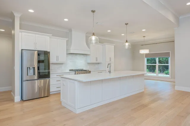 a large kitchen with stainless steel appliances granite countertop a lot of counter space and wooden floors