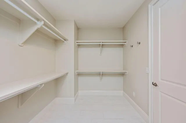 an empty room with a ceiling fan and window