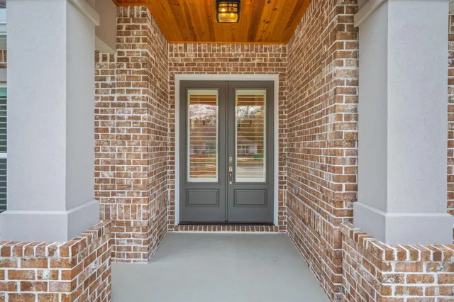 an empty room with windows and fireplace