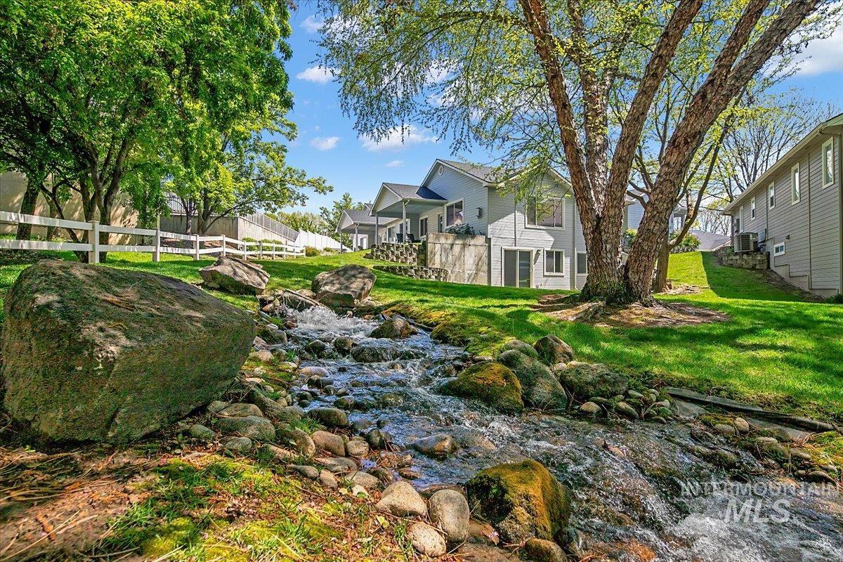 725 North Eagle Road Eagle, ID 83616 - Photo 36 of 45 Natural rock-lined stream meandering through a verdant backyard with mature trees