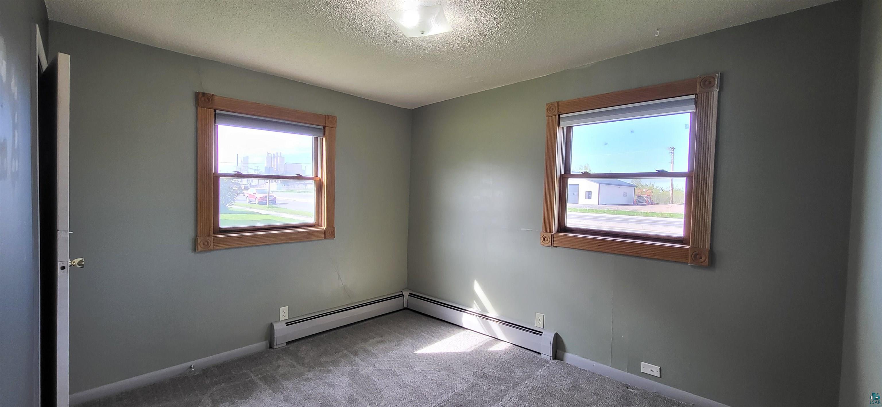 56 East 2nd Street Superior, WI 54880 - Photo 12 of 18 Interior room featuring gray wall paint and two windows with natural wood trim