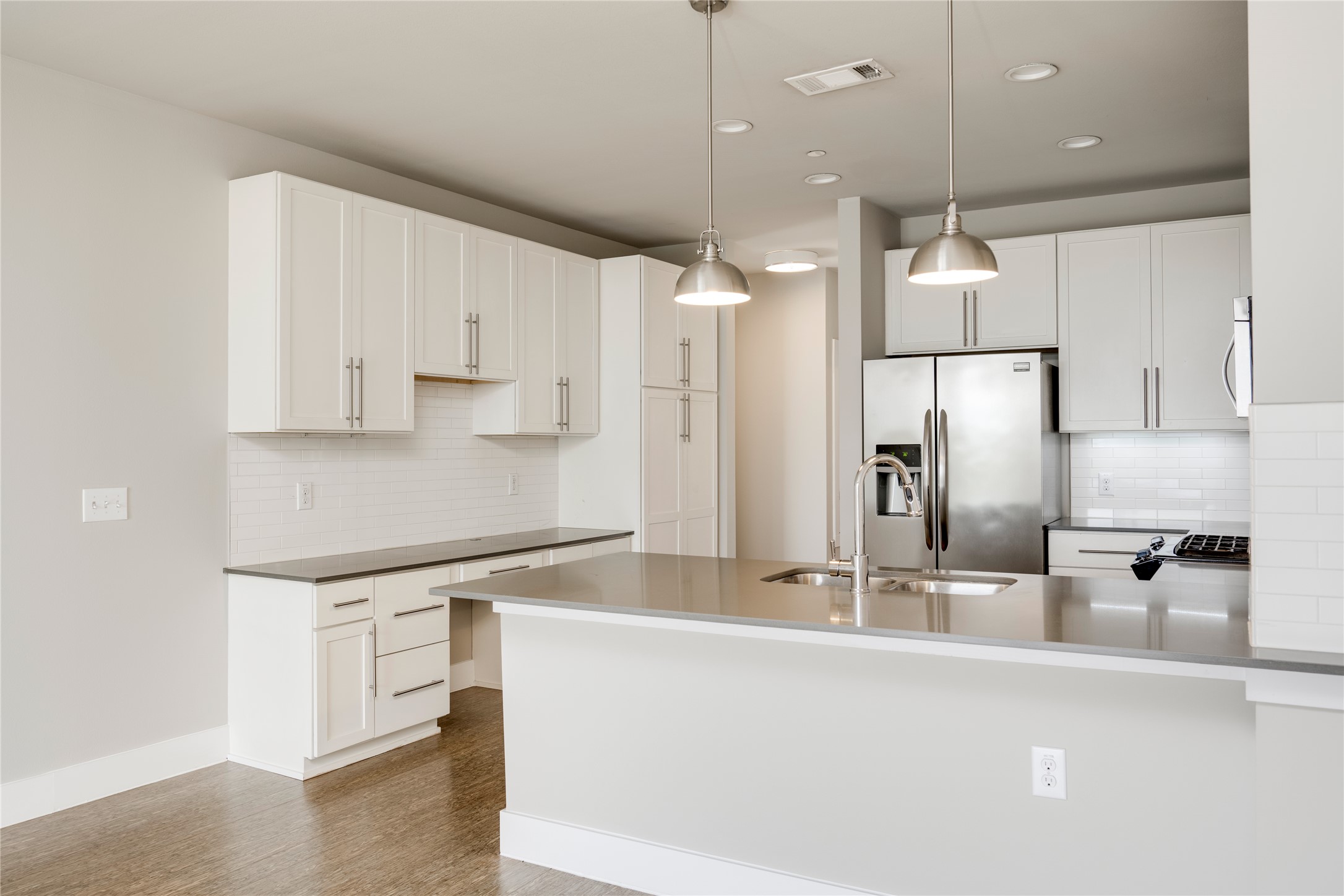 2724 Treble Lane, Unit 324 Austin, TX 78704 - Photo 7 of 29 Kitchen with appliances with stainless steel finishes, a sink, tasteful backsplash, a peninsula, and pendant lighting