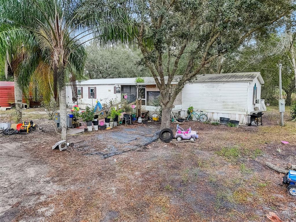205 Little Brown Church Road Pierson, FL 32180 - Photo 1 of 1 a view of a backyard with a car parked in it