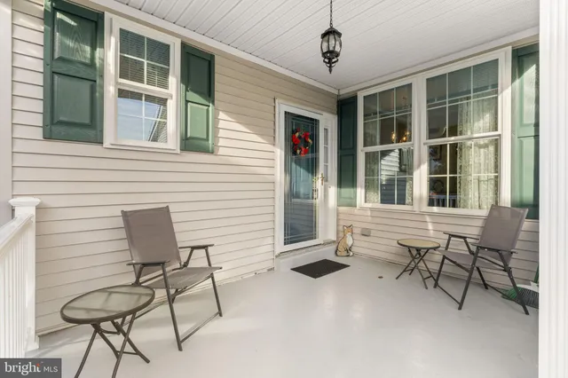 a balcony with table and chairs and potted plants