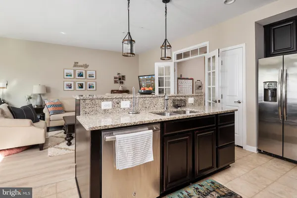 a kitchen with stainless steel appliances granite countertop a sink and refrigerator