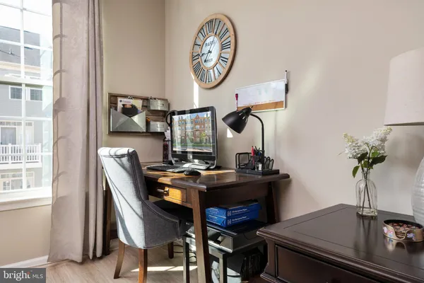 a view of a workspace with furniture and a window