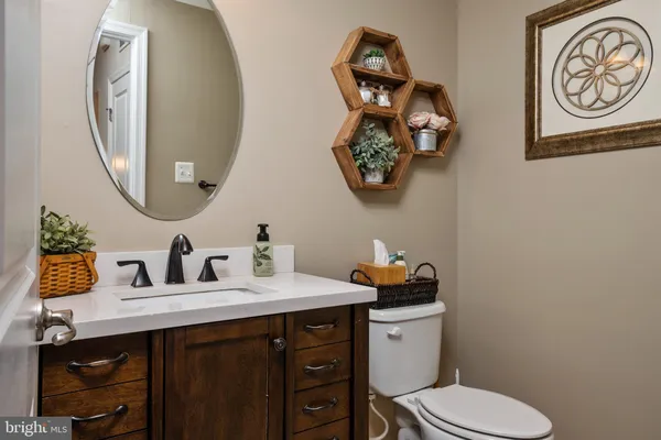 a bathroom with a toilet sink vanity and mirror