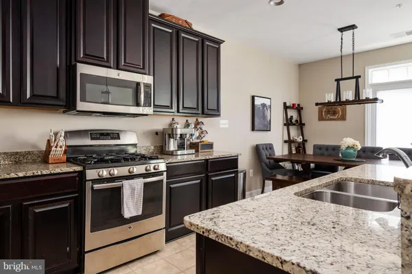 a kitchen with stainless steel appliances granite countertop a stove top oven microwave and refrigerator