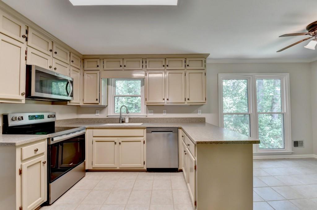 3791 Old Bridge Way Duluth, GA 30096 - Photo 20 of 58 a kitchen with stainless steel appliances granite countertop a stove a sink dishwasher and a microwave oven with cabinets