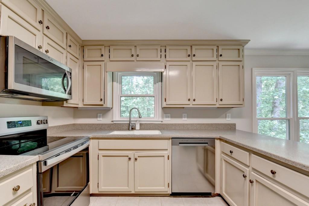 3791 Old Bridge Way Duluth, GA 30096 - Photo 21 of 58 a kitchen with granite countertop white cabinets and white appliances