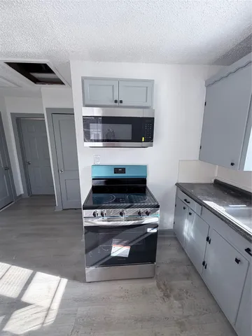 a kitchen with granite countertop white cabinets and stainless steel appliances