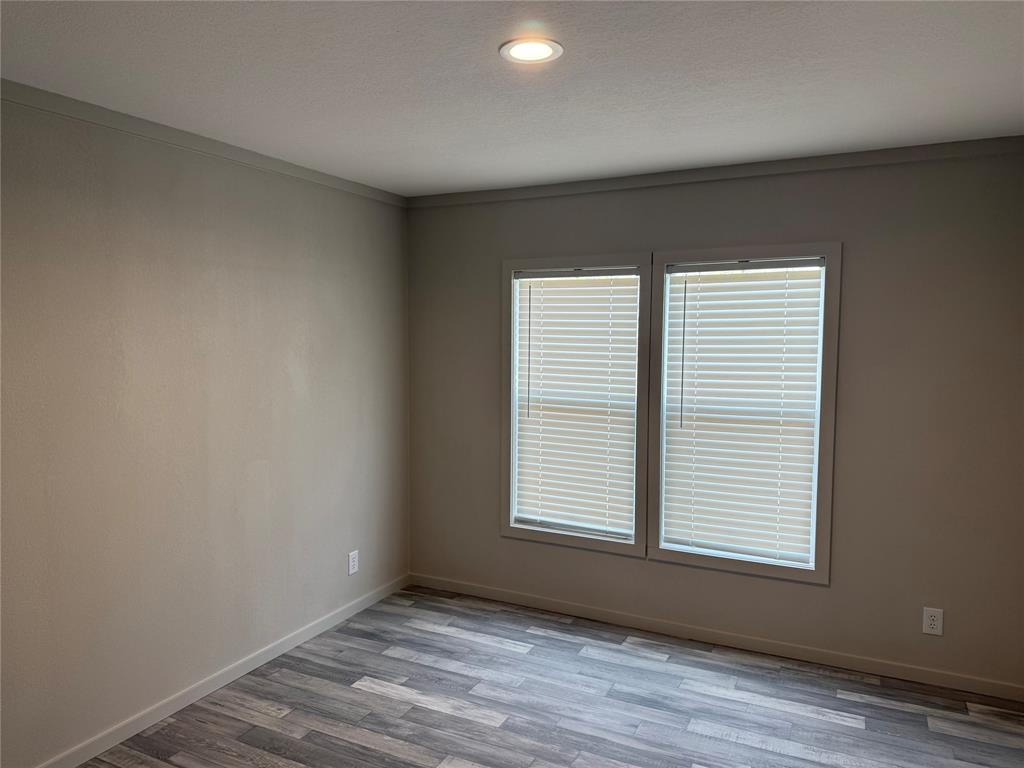 358 Reast Road Whitesboro, TX 76273 - Photo 14 of 21 an empty room with wooden floor and windows
