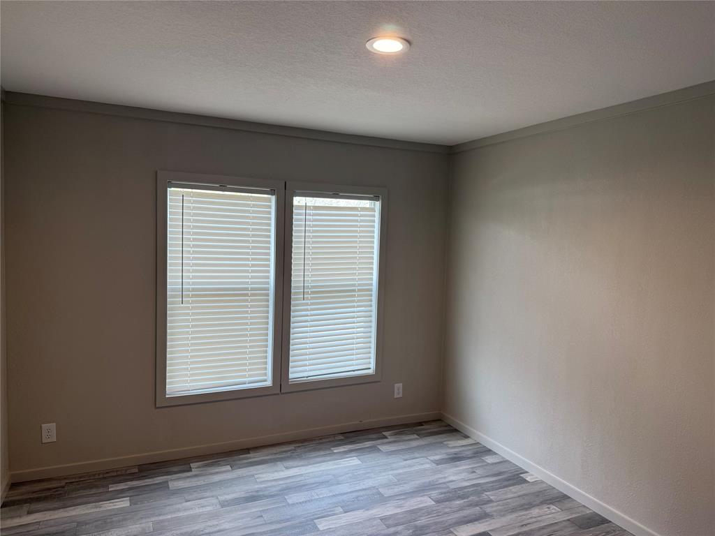 358 Reast Road Whitesboro, TX 76273 - Photo 15 of 21 an empty room with wooden floor and windows