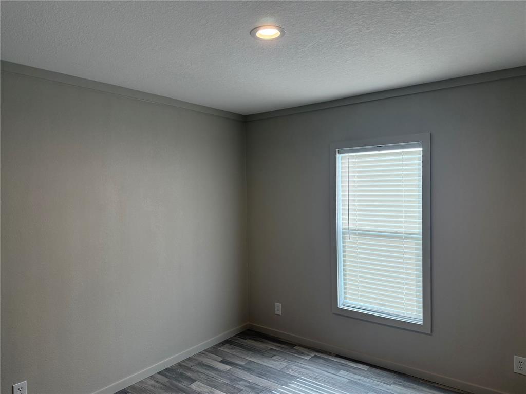 358 Reast Road Whitesboro, TX 76273 - Photo 16 of 21 an empty room with wooden floor and windows