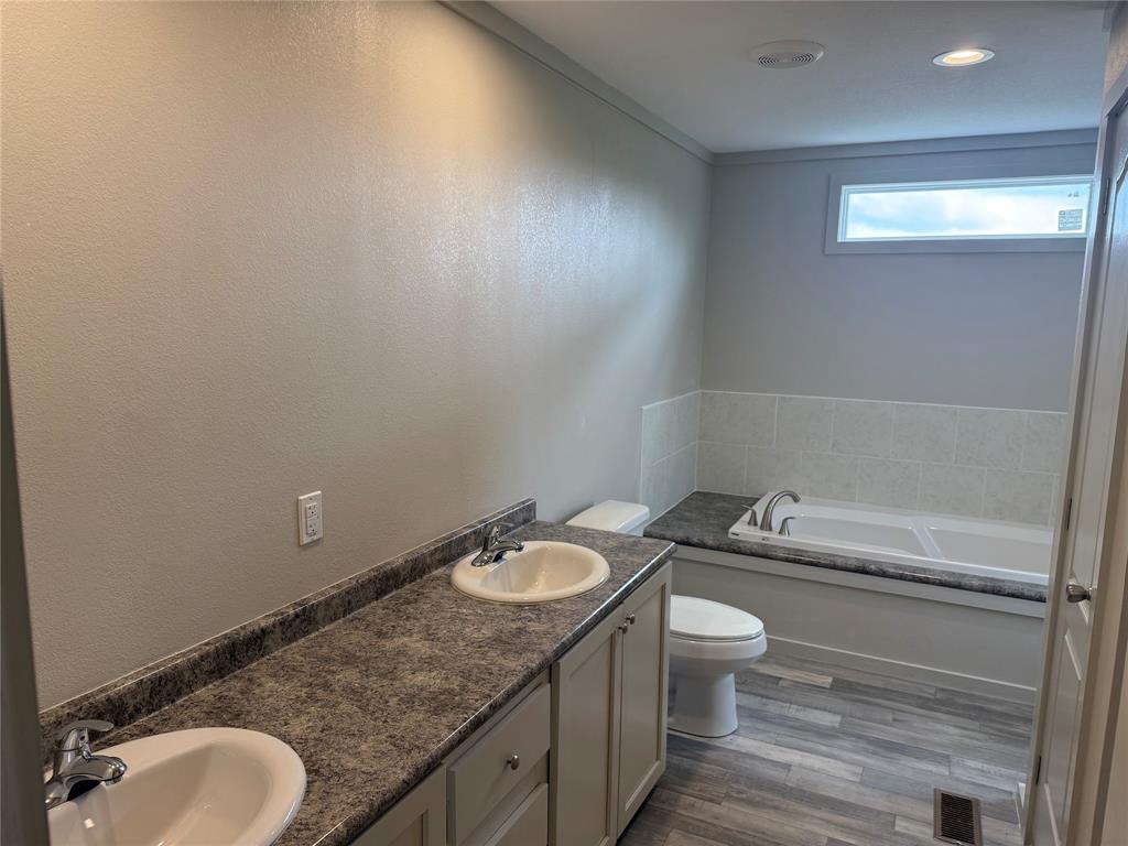 358 Reast Road Whitesboro, TX 76273 - Photo 8 of 21 a bathroom with a granite countertop sink a toilet and a mirror