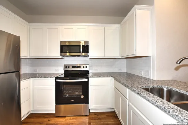 a kitchen with a sink stove and microwave