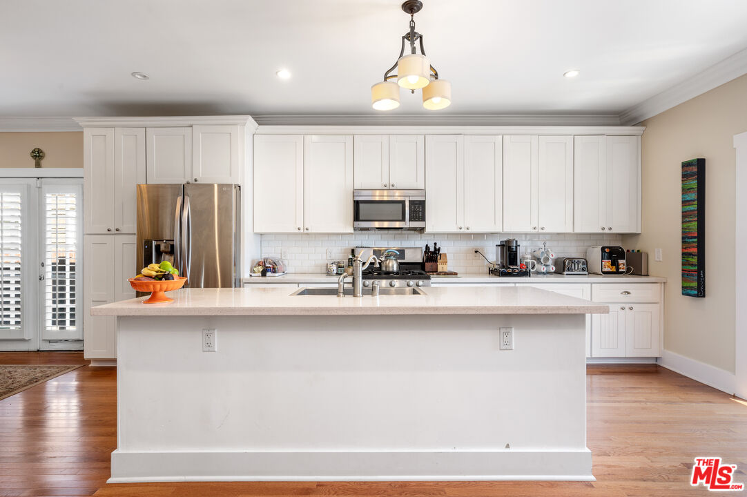 4530 West Washington Boulevard Los Angeles, CA 90016 - Photo 14 of 46 a kitchen with stainless steel appliances granite countertop a refrigerator a stove top oven a sink and dishwasher with wooden floor