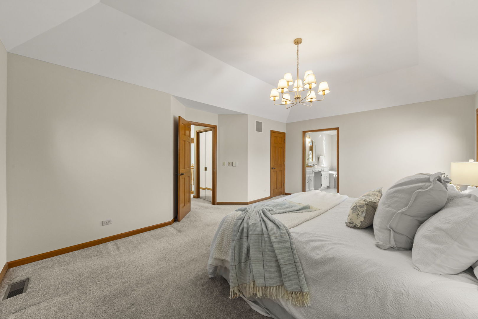 6621 Greene Road Woodridge, IL 60517 - Photo 20 of 42 a bedroom with a large bed and a chandelier