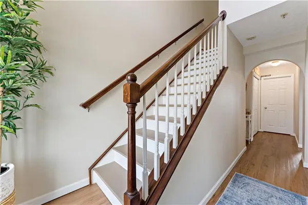 a view of staircase with wooden floor and frames on wall