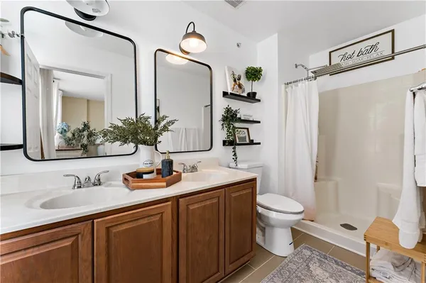 a bathroom with a granite countertop sink toilet and shower