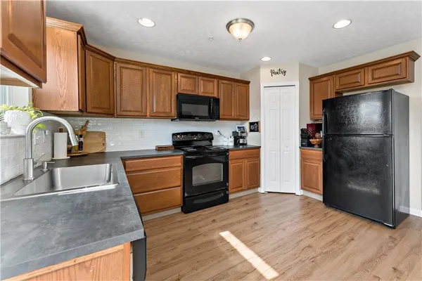 a kitchen with granite countertop a refrigerator and a sink