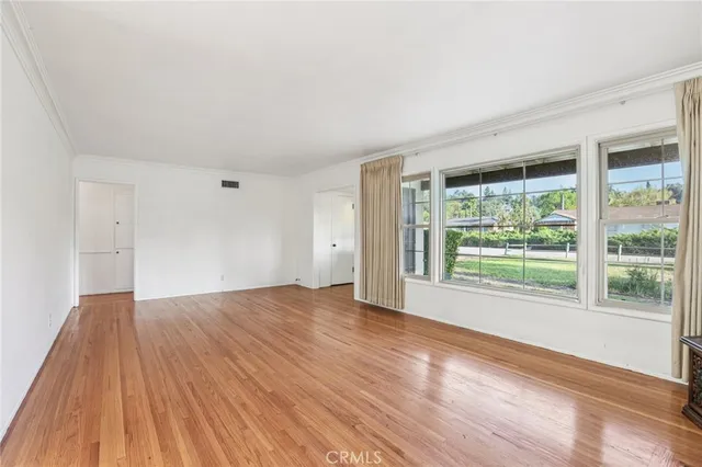 a view of a room with wooden floor and a ceiling fan