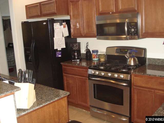 599 Needles Court Reno, NV 89521 - Photo 11 of 13 a kitchen with granite countertop stainless steel appliances and wooden cabinets