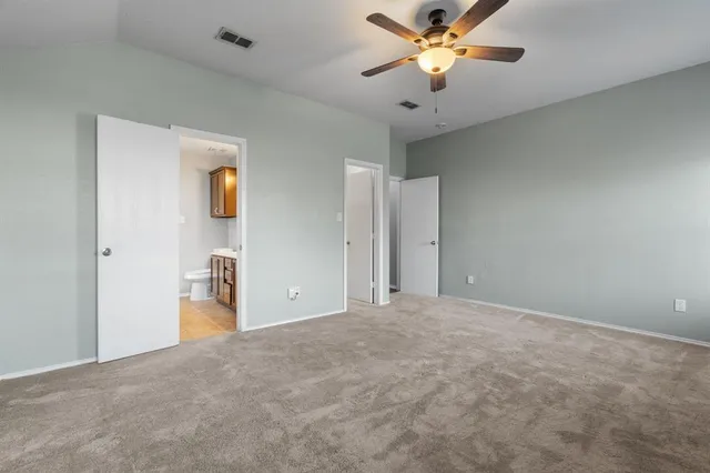 a view of a bedroom with a ceiling fan and a chandelier fan