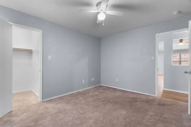 a view of an empty room with a chandelier fan