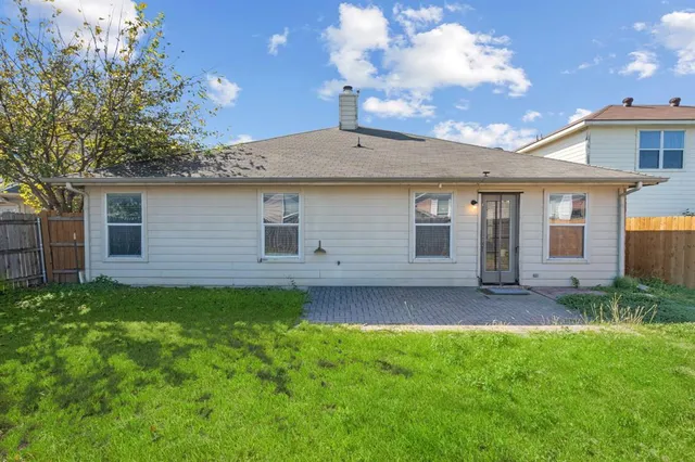 a backyard of a house with table and chairs