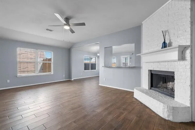 an empty room with large windows and a fireplace