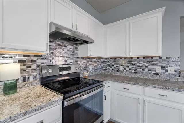 a kitchen with granite countertop a stove and a sink