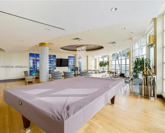 a room with pool table and windows