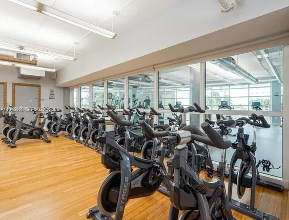 a room with gym equipment and large windows