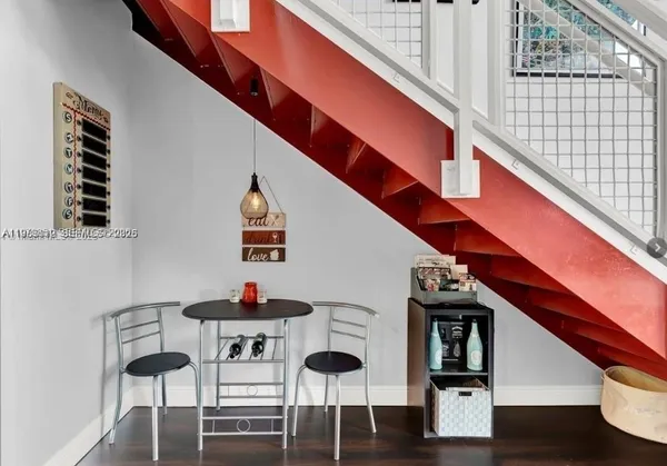 a dining room with wooden floor and white walls