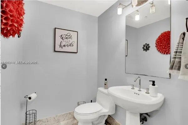 a bathroom with a sink mirror and toilet