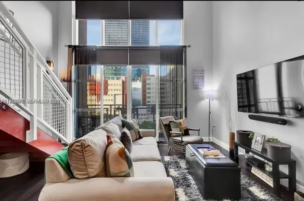 a living room with furniture tv and a large window