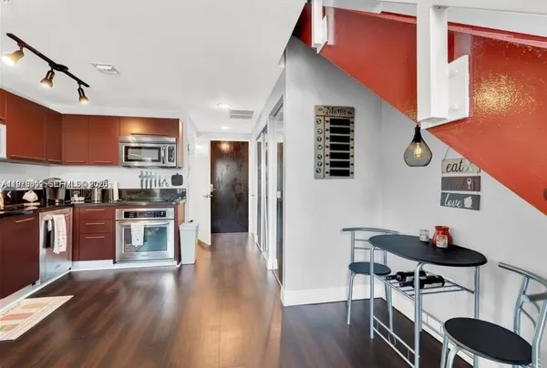 a kitchen with stainless steel appliances granite countertop a refrigerator a stove and a wooden floors