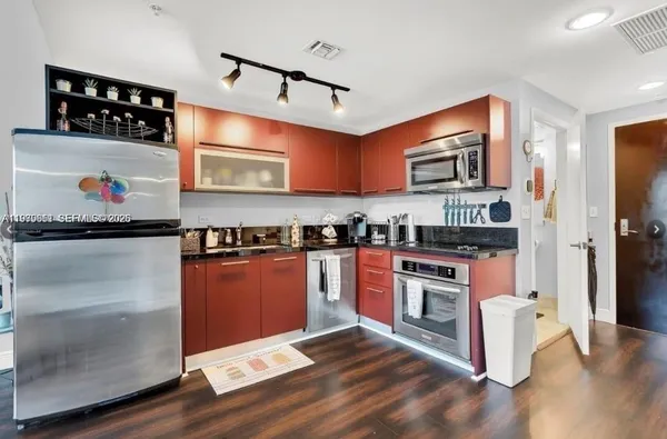 a kitchen with stainless steel appliances granite countertop a stove a sink and a refrigerator