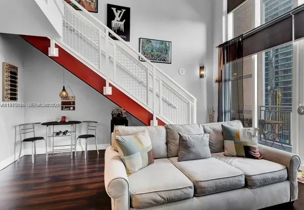 a living room with furniture and wooden floor