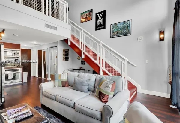 a living room with furniture and wooden floor