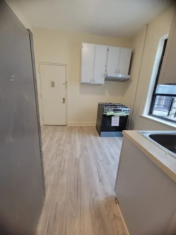 a kitchen with a wooden floor and a stove top oven