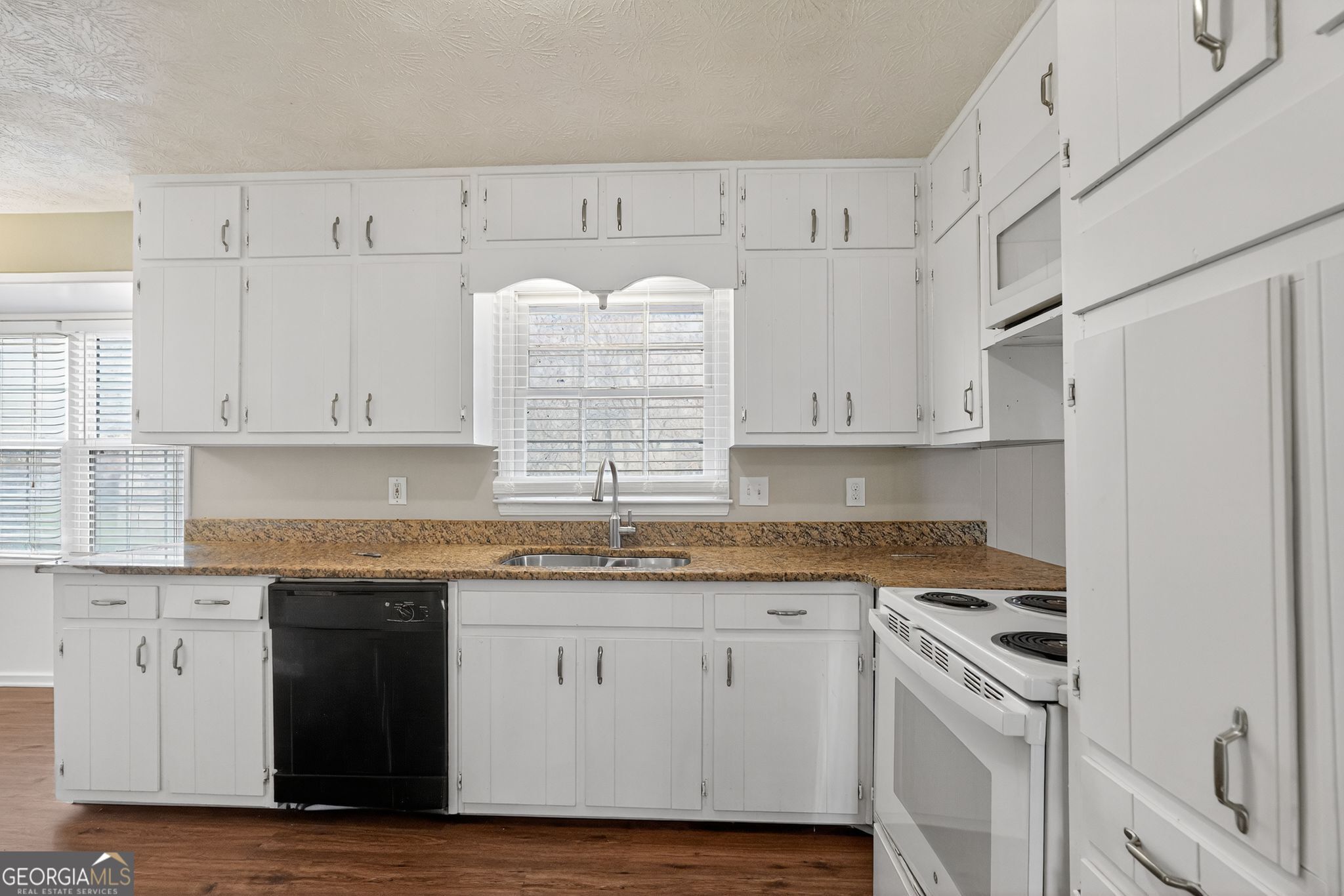 4716 Jakes Trail Decatur, GA 30034 - Photo 10 of 34 a kitchen with granite countertop white cabinets and white appliances
