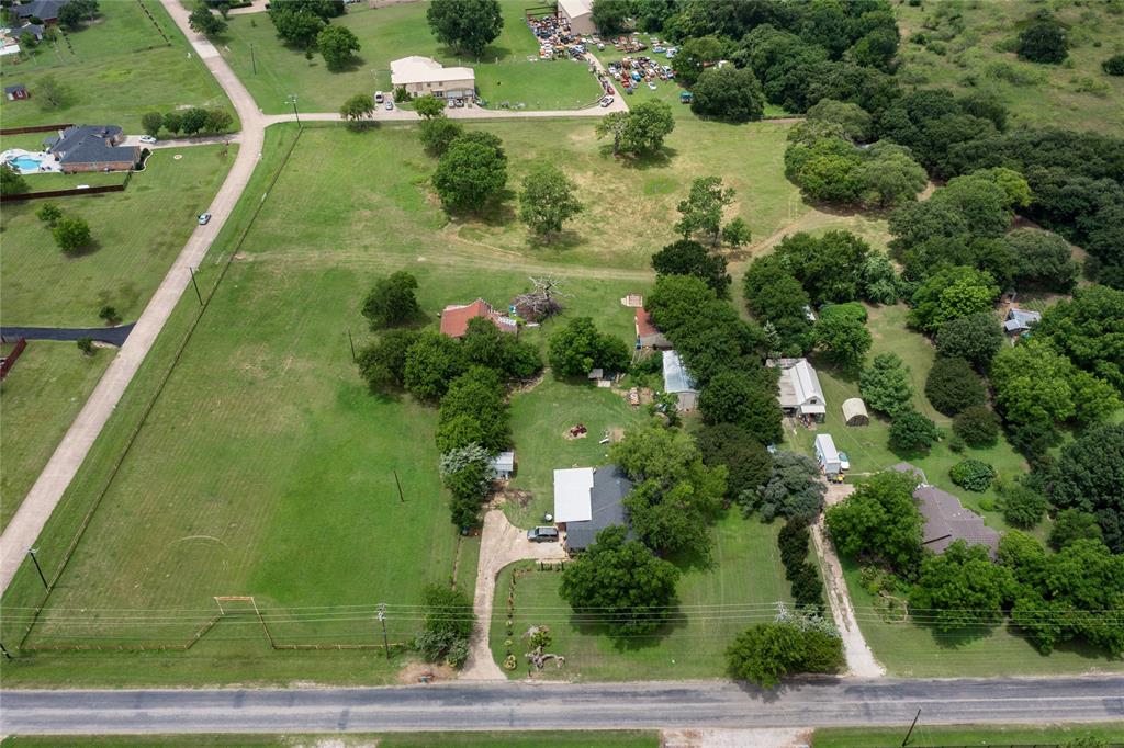 an aerial view of residential houses with outdoor space and trees