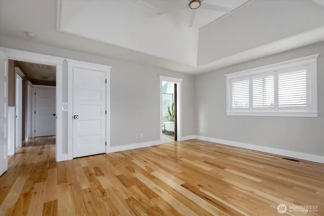 a view of an empty room with a window and wooden floor